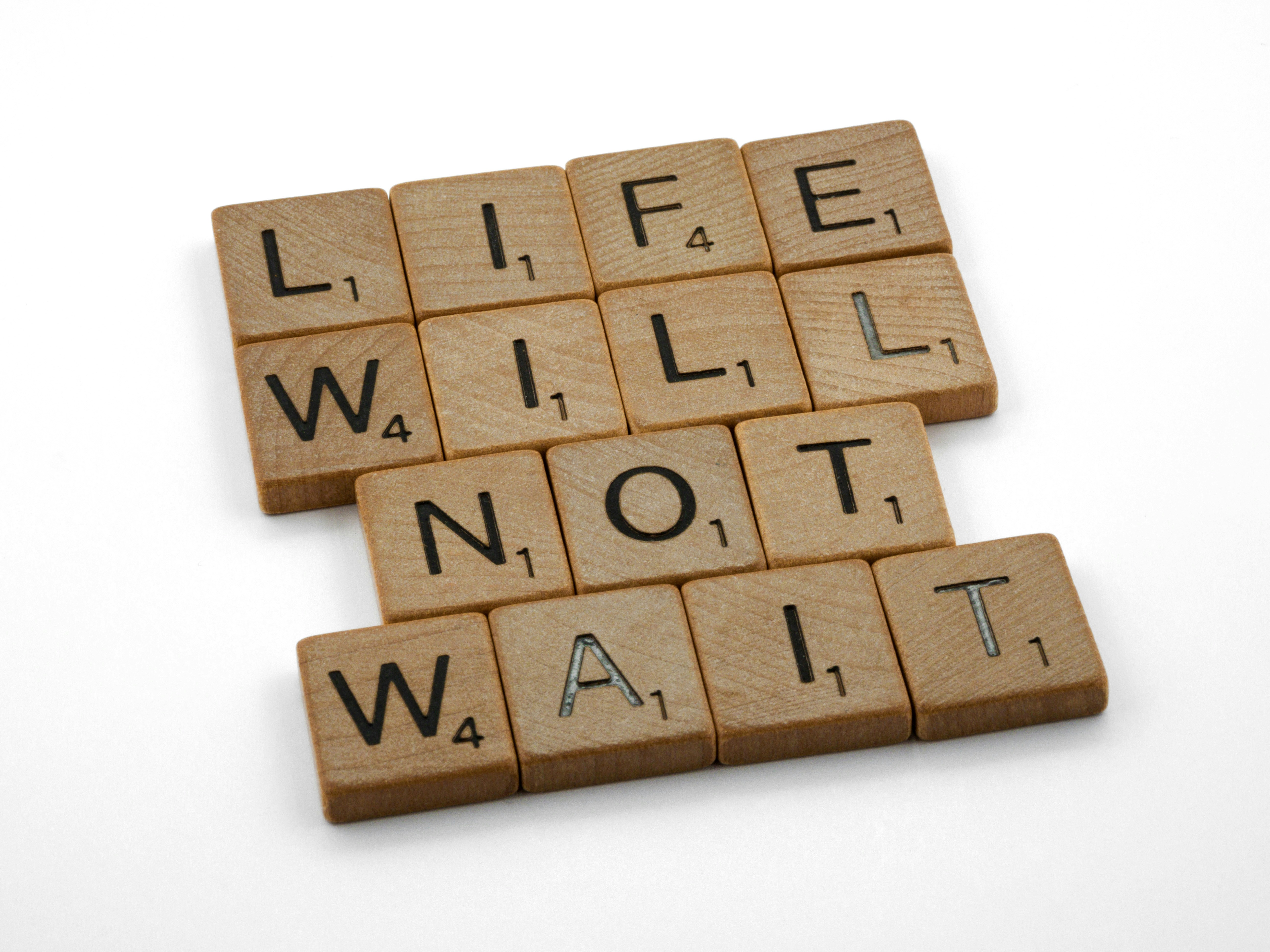 picture of "scrabble word game' blocks assembled to spell out "time will not wait"